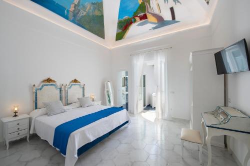 a bedroom with a bed and a desk and a television at Terrazza Zaffiro in Positano