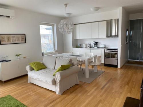 a living room with a white couch and a kitchen at Papli Seaview Apartment in Pärnu