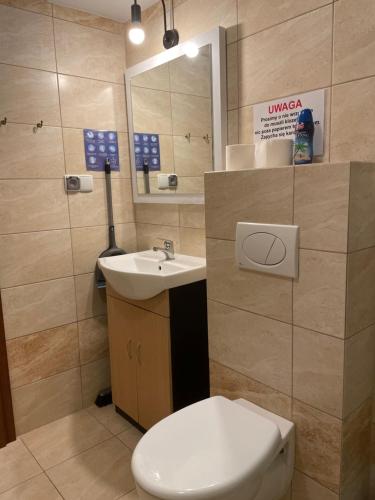 a bathroom with a white toilet and a sink at POKOJE FRAJDAA NIECHORZe in Niechorze