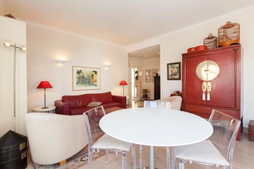 un salon avec une table et des chaises blanches dans l'établissement 2-Br Apartment in City Center, à Cannes