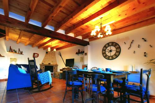 a dining room with a table and a clock on the wall at Casa rural La abuela Nines in Ligos