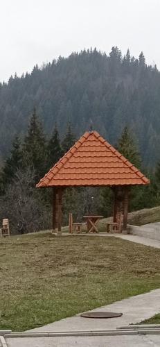 an orange roofed picnic shelter in a park at LAKI apartman in Zaovine