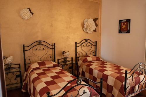 two beds in a room with checkered sheets at "Il Miglio" Country House in Pettorano sul Gizio