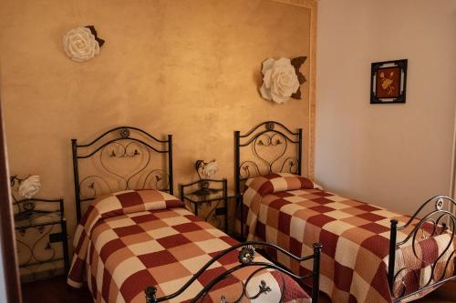 duas camas num quarto com lençóis xadrez em "Il Miglio" Country House em Pettorano sul Gizio