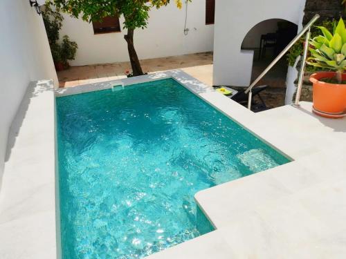 une piscine au milieu d'une maison dans l'établissement Casa el Patio del Limón, con piscina, à Montecorto