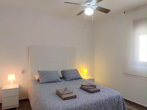 une chambre avec un lit avec un ventilateur de plafond dans l'établissement Casa el Patio del Limón, con piscina, à Montecorto