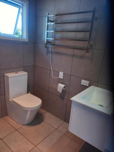 bagno con servizi igienici, lavandino e finestra di North Hideaway a Pukenui