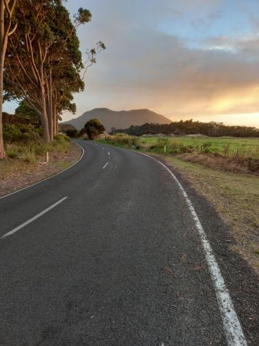 an empty road in the middle of a field at North Hideaway in Pukenui