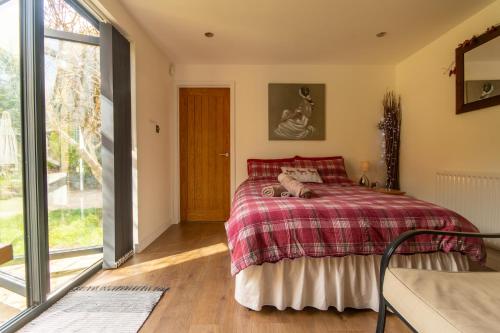a bedroom with a bed and a large window at The Mills Guesthouse in Hatfield