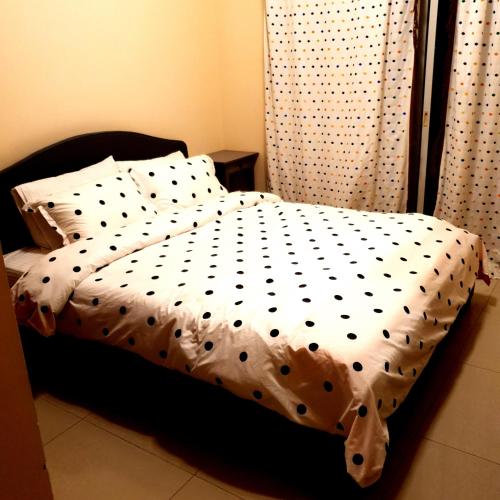 a bed with a black and white comforter and pillows at قرية الحمرا راس الخيمة in Ras al Khaimah