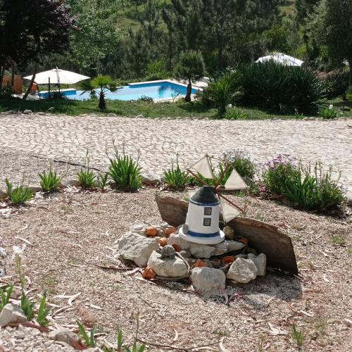 a garden with a lighthouse on the ground next to a pool at Moinho da Amélia in Cadaval