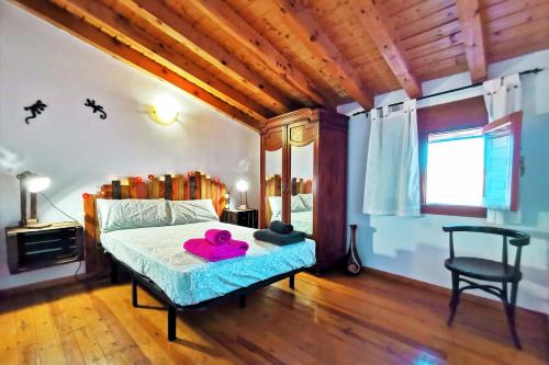 Un dormitorio con una cama con una toalla rosa. en Casa rural La abuela Nines, en Ligos