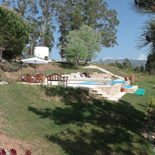 a swimming pool in a grassy yard with an umbrella at Moinho da Amélia in Cadaval