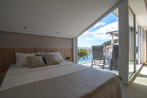 a bedroom with a large bed and a balcony at SYMPHONY in Petrovac na Moru