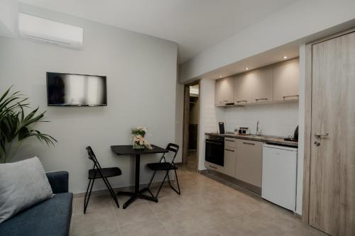 a kitchen and a living room with a table and chairs at AIORA yard in Ammouliani