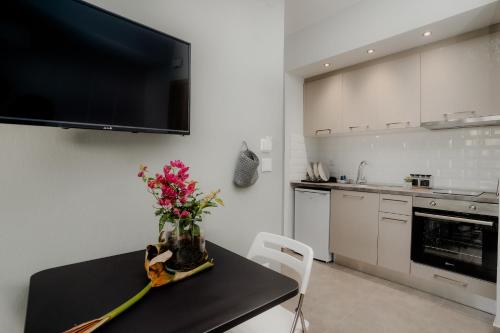 a kitchen with a table with a vase of flowers on it at AIORA yard in Ammouliani