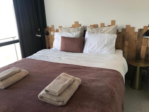 a bedroom with a large bed with towels on it at Luxury Seaview Apartment with free private garage in Ostend