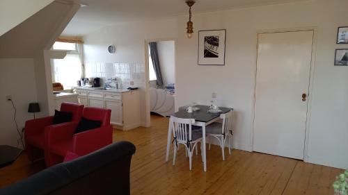 a living room with a table and chairs and a kitchen at hotel 't Doktershus in Lemmer