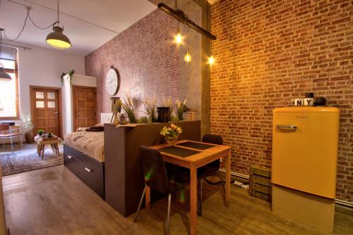 - une chambre avec un lit, une table et un réfrigérateur dans l'établissement New York Loft - Fully equipped and available long-term - Perfect location IN city center, à Namur