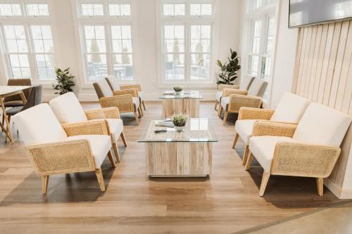 a waiting room with chairs and tables and windows at Grasshopper Inn in Ogunquit