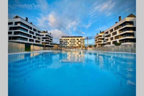 a large swimming pool in front of some buildings at Apartamento Ático Miramar, Luanco in Luanco