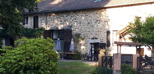 a brick house with a picnic table in the yard at La grange du moulin in Saint-Christophe