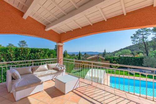 un patio extérieur avec un canapé et une piscine dans l'établissement LA BASTIDE DU MAZEL, à Banne