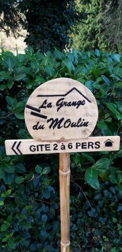 a sign in front of a bush with a sign at La grange du moulin in Saint-Christophe