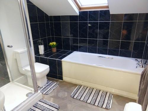 a bathroom with a bath tub and a toilet at Derwent Street Apartment 3 - Self Contained - 2 Bed Self Catering Apartment in Workington