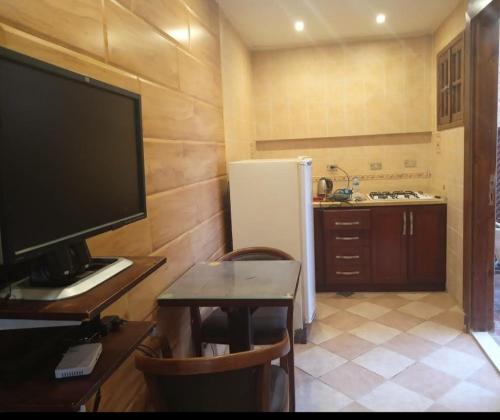 a kitchen with a desk with a television and a refrigerator at Studio in Sharm El Sheikh