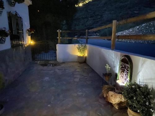 a patio at night with lights on the wall at Finca Las Fuentezuelas in Carataunas