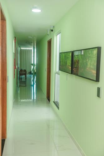 an empty hallway with green walls and white floors at Pousada Central de Arraial in Arraial do Cabo