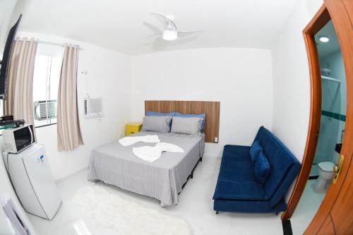 a bedroom with a bed and a blue chair at Pousada Central de Arraial in Arraial do Cabo