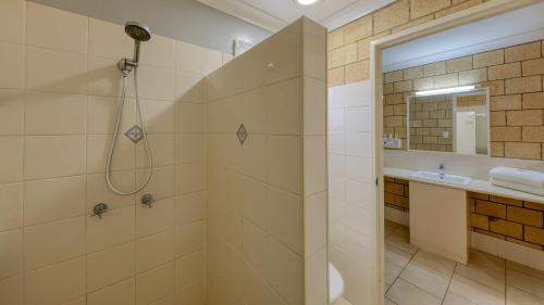 a bathroom with a shower and a sink at Jacaranda Country Motel in Saint George