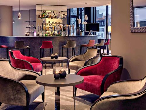 a lobby with red chairs and tables and a bar at Mercure Clermont Ferrand centre Jaude in Clermont-Ferrand