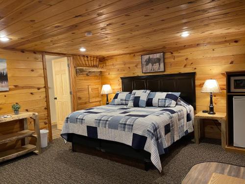 a bedroom with a bed in a log cabin at Mountain View Lodge & Cabins in Hill City