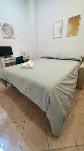 een bed in een kamer met een bureau en een sprei bij Casa Cristina in città in Reggio di Calabria