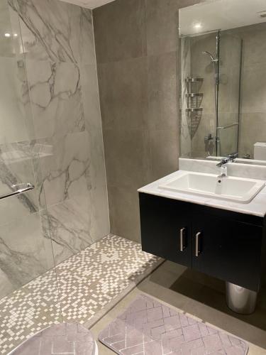 a bathroom with a sink and a shower at Maqeela Luxury Studio in King Abdullah Economic City
