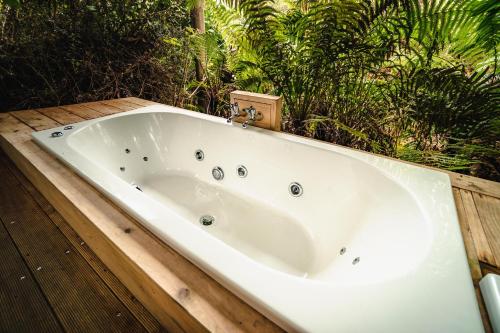 una vasca da bagno situata sulla parte superiore di una terrazza in legno di Franz Josef Treetops a Franz Josef