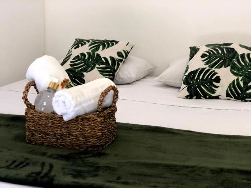 a basket with towels and a bed in a room at Paraíso Capitólio Suítes Pousada in Capitólio