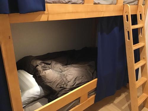 a bed on the bottom bunk of a bunk bed room at Kakunodate Guest House Choux in Senboku