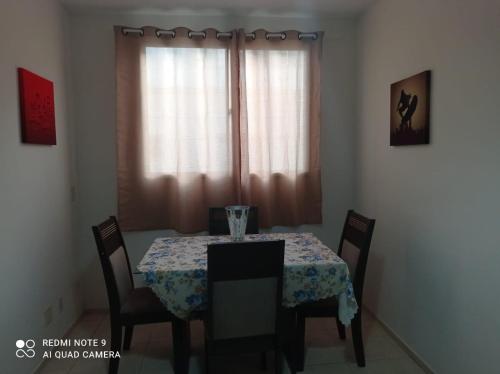 a dining room table and chairs with a table and a window at Apto se sentindo em casa in Campos dos Goytacazes