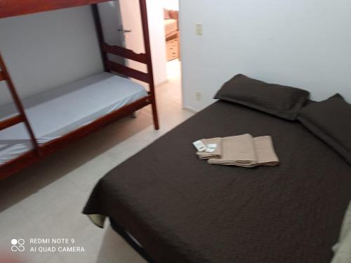 a bedroom with a black bed with a pair of towels on it at Aluguel Agua Marinha in Campos dos Goytacazes