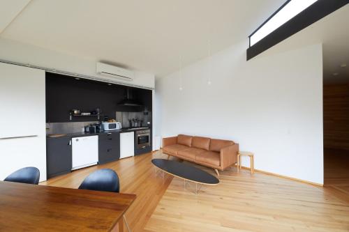 a living room with a couch and a table at Denison Rivulet Retreats in Bicheno