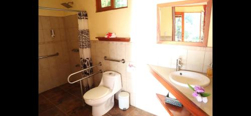 y baño con aseo, lavabo y ducha. en La Ceiba Tree Lodge, en Tilarán