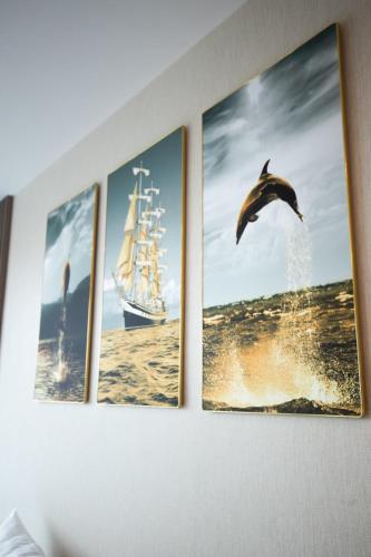 a group of four pictures hanging on a wall at Sunshine Hotel Móng Cái in Móng Cái