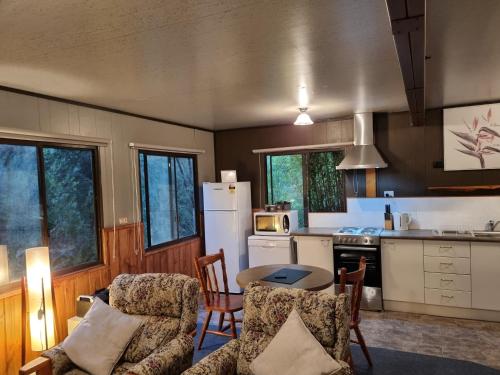 a kitchen with a table and chairs and a kitchen with a refrigerator at Roland B&B in Claude Road