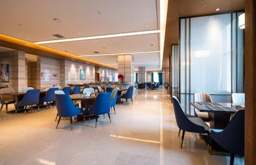 a dining room with blue chairs and tables at Shangrao International Hotel in Shangrao