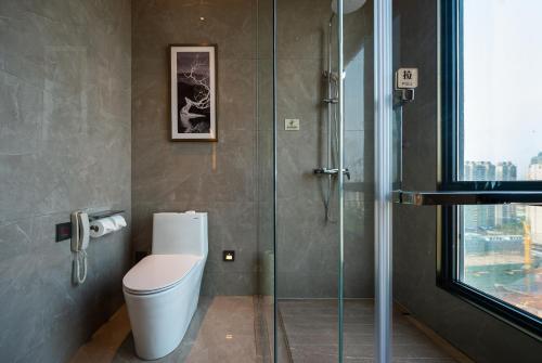 a bathroom with a toilet and a glass shower at Shangrao International Hotel in Shangrao