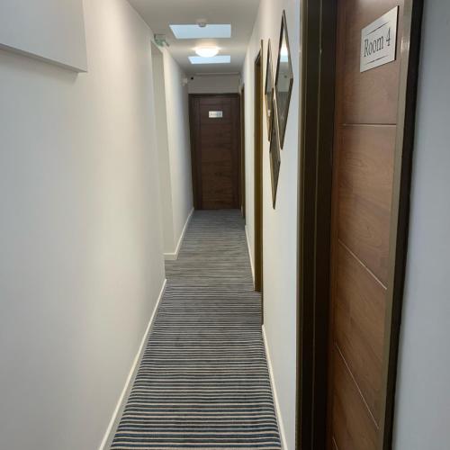 a hallway with a long aisle with a door at De Regency Style Hotel in Redditch